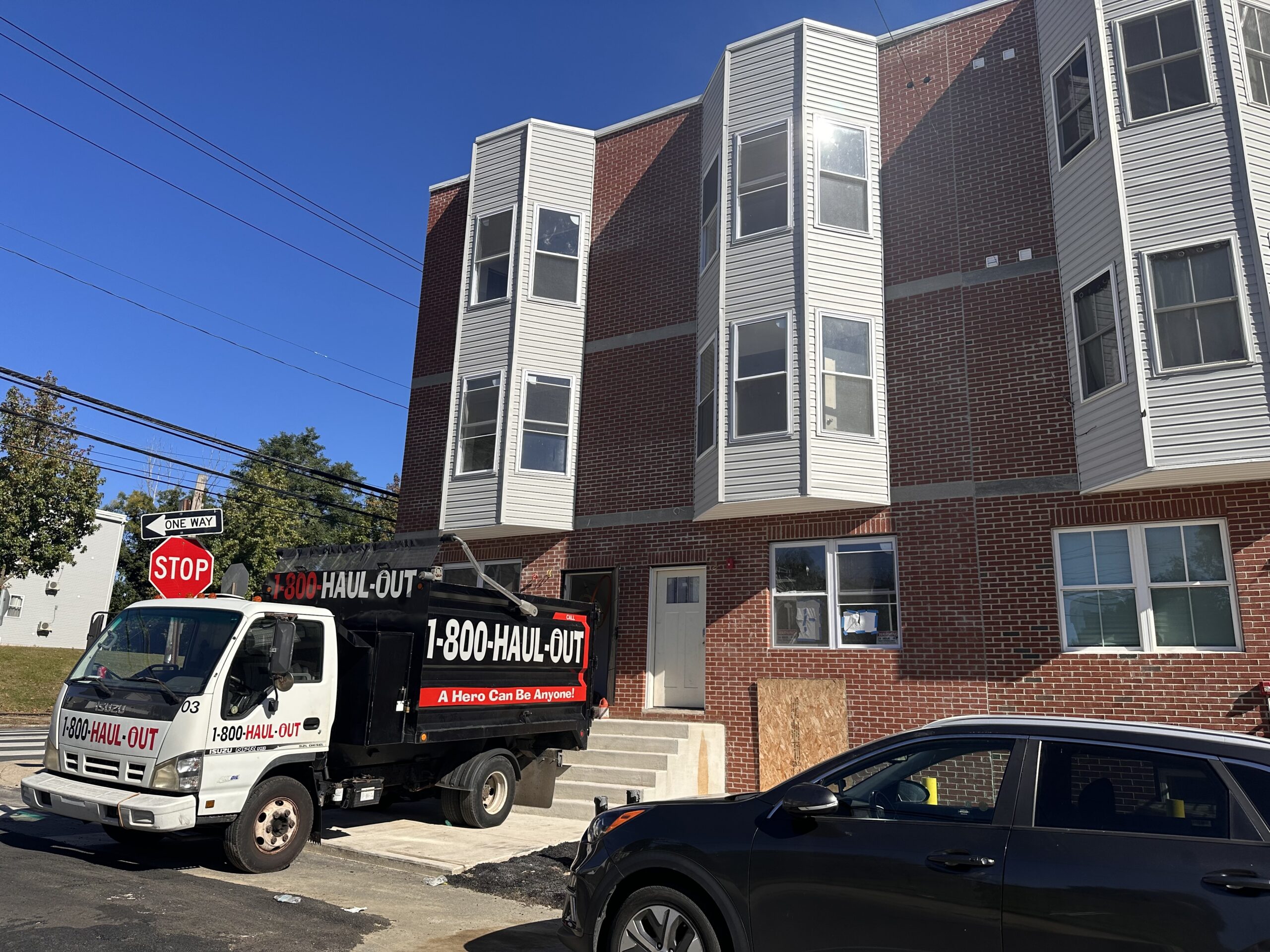 1-800-Haul-Out Truck 3 parked outside a multistory new construction property in North Philadelphia.
