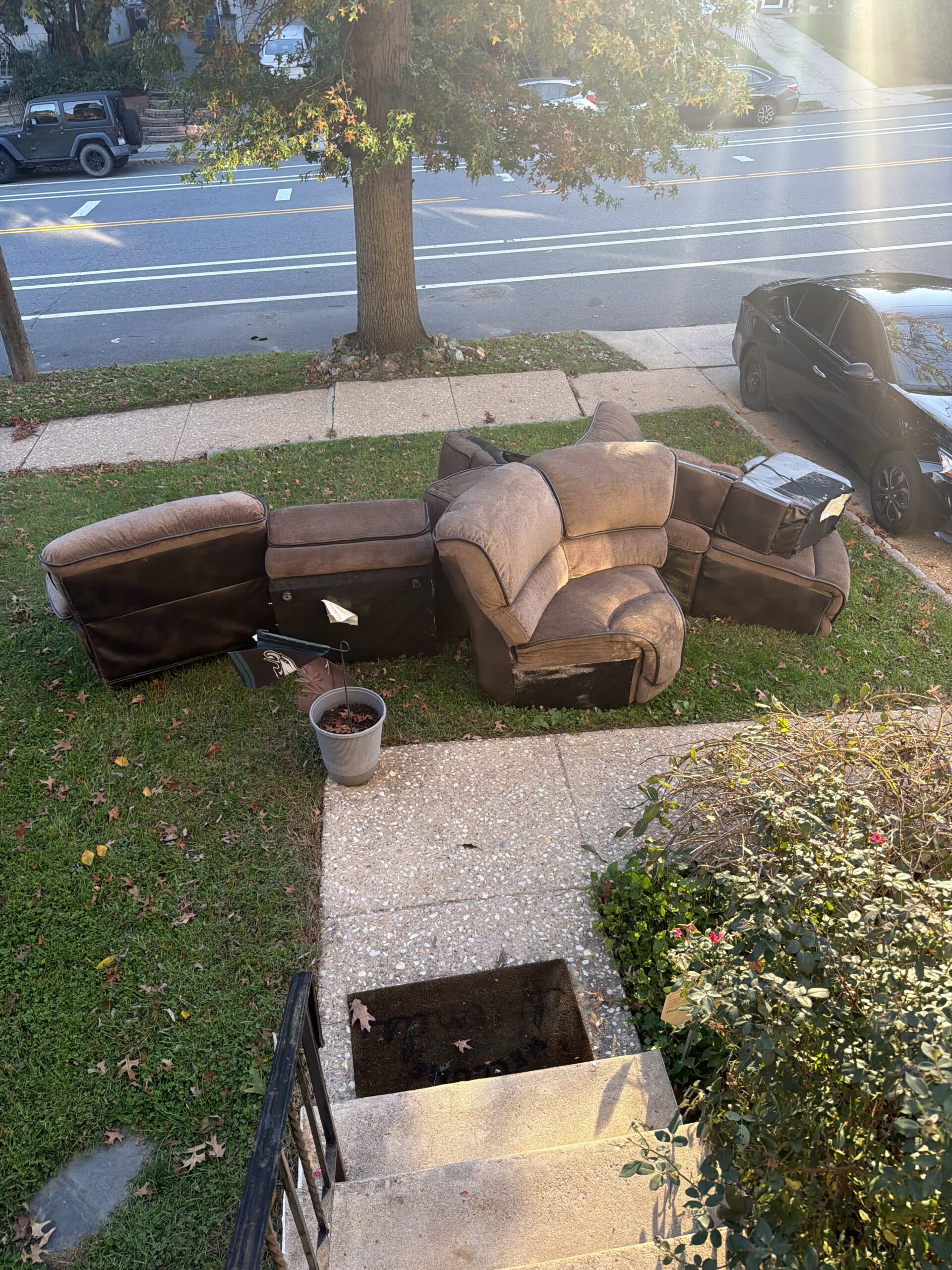 Old brown sectional separated into sections outside a Roxborough home, ready for Haul-Out pickup.